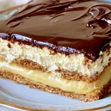 Delicious no-bake eclair cake topped with chocolate icing and whipped cream