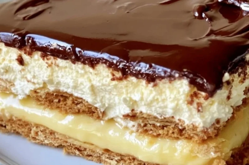 Delicious no-bake eclair cake topped with chocolate icing and whipped cream