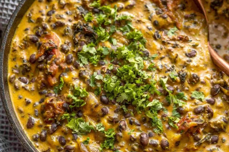 Cozy creamy black bean curry served in a bowl with fresh herbs and spices