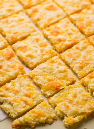 Cozy homemade sourdough crackers topped with cheddar cheese
