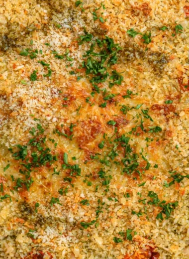 Cozy white bean pesto bake topped with fresh basil and cheese