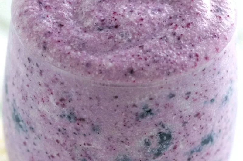 Healthy blueberry banana protein smoothie in a glass with fresh fruits
