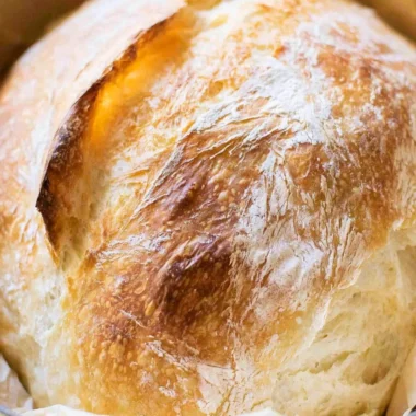 A freshly baked loaf of no-fail sourdough bread on a wooden table