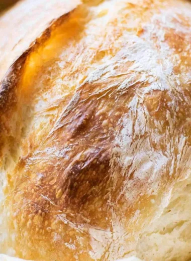 A freshly baked loaf of no-fail sourdough bread on a wooden table