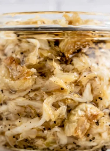 Jar of homemade roasted garlic sauerkraut with cloves of garlic